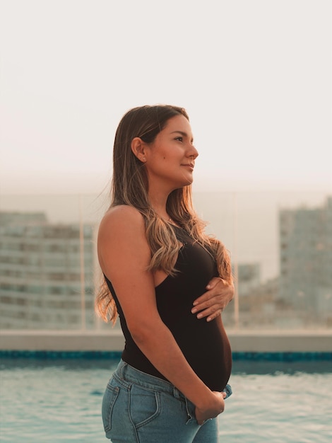 Linda mulher latina grávida olhando para o céu