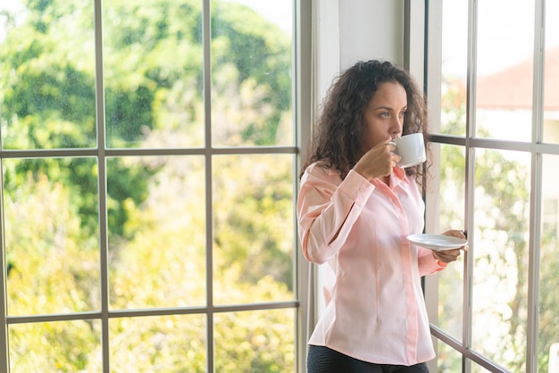 linda mulher latina tomando café da manhã