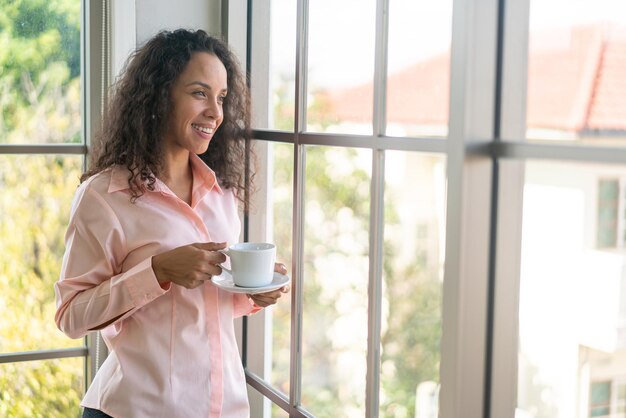 linda mulher latina tomando café pela manhã