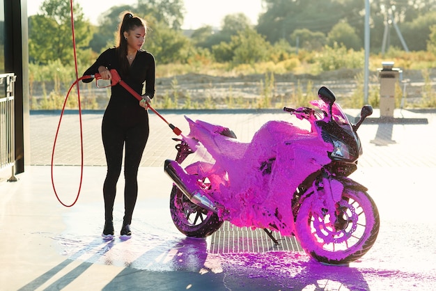 Linda mulher lavando uma motocicleta