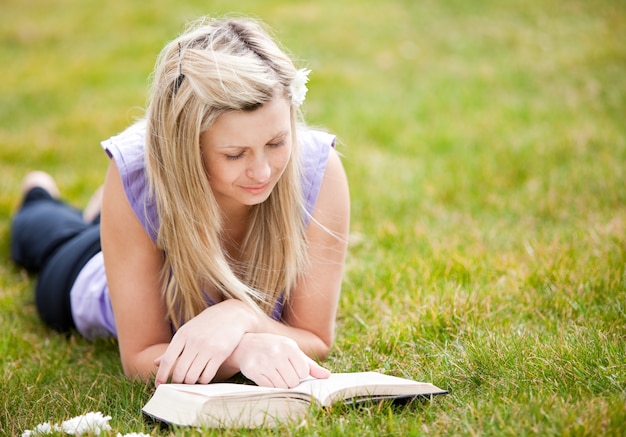 Linda mulher lendo um livro em um parque