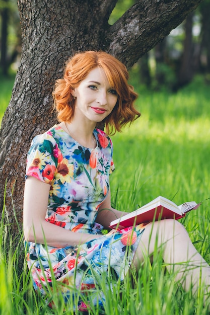 Linda mulher lendo um livro no jardim primavera