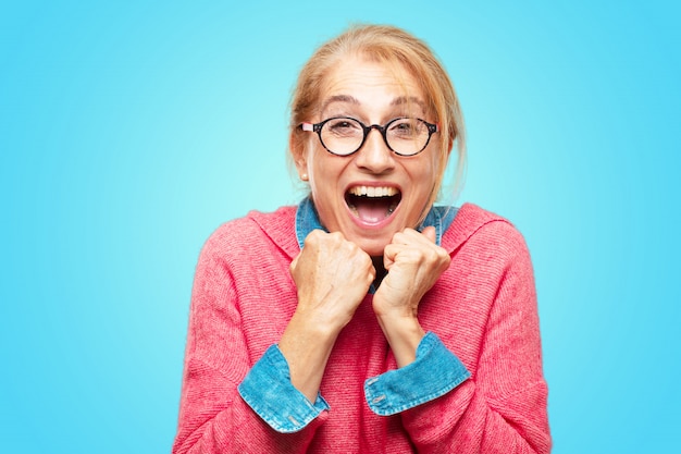 Linda mulher loira adulta com uma expressão feliz surpresa, olhos bem abertos e largo sorriso, com