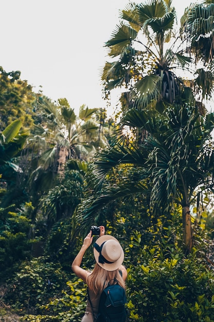 Linda mulher loira caucasiana asiática viajar turista mochileiro mulher andando apreciando tirar fotos na selva Sanya. Viajando pela Ásia, conceito de estilo de vida ativo. Descobrindo Hainan, China