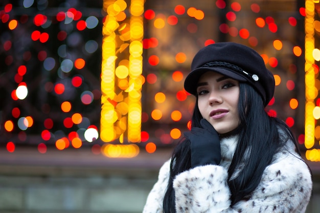 Linda mulher loira com boné preto posando na rua