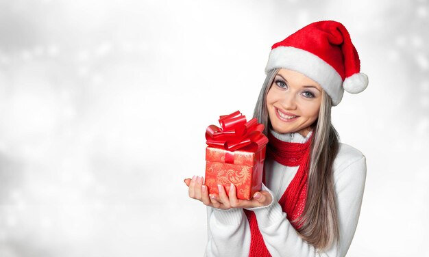 Linda mulher loira com chapéu de Papai Noel com presente