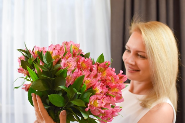 Linda mulher loira com lindo buquê de buquê de flores frescas para menina