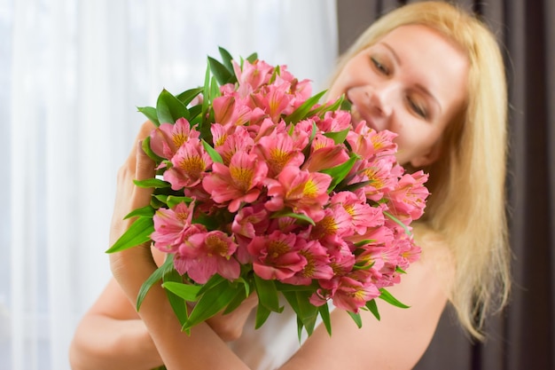 linda mulher loira com um lindo buquê de flores frescas para entrega de flores para meninas