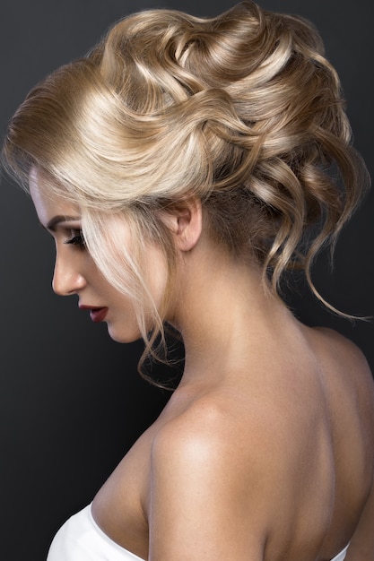 Linda mulher loira com uma pele perfeita, maquiagem de noite, penteado de casamento