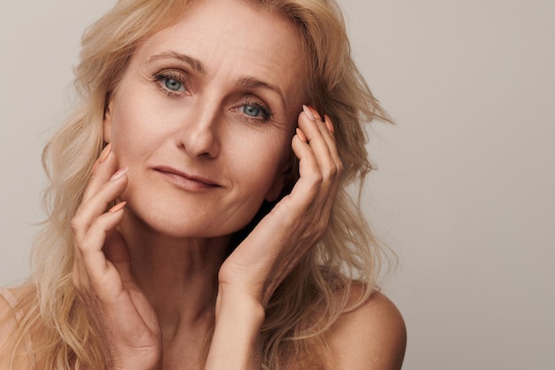 Linda mulher loira de meia-idade sorrindo rosto olhando retrato da câmera Elegante senhora madura sem maquiagem 50 anos de idade closeup isolado no branco