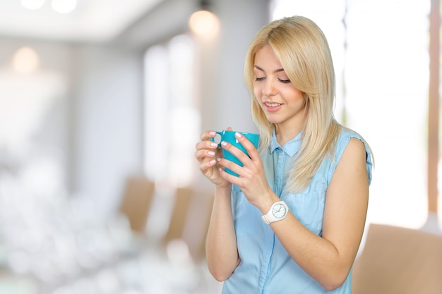 Linda mulher loira segurando uma xícara de café