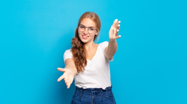 linda mulher loira sorrindo alegremente dando um abraço caloroso, amigável e amoroso de boas-vindas, sentindo-se feliz e adorável