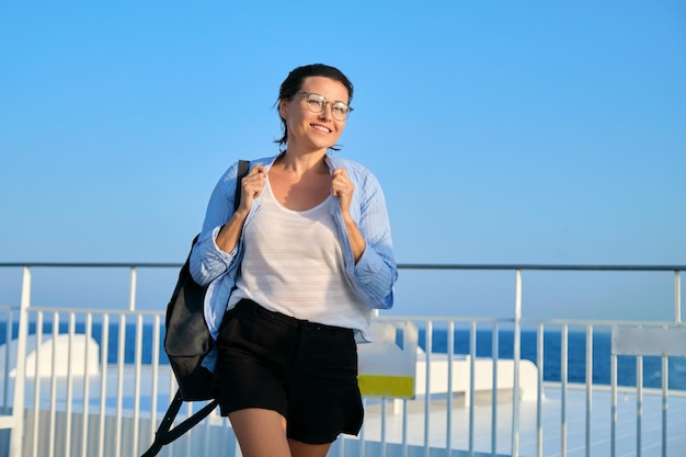 Linda mulher madura feliz no convés da balsa do navio desfrutando da viagem marítima