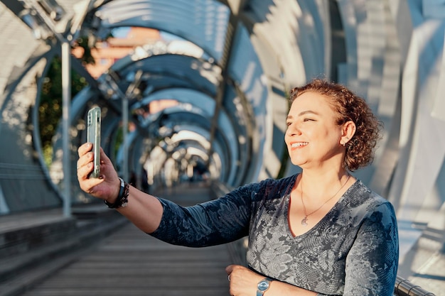Foto linda mulher madura posando enquanto toma selfie pelo conceito de estilo de vida da câmera do smartphone