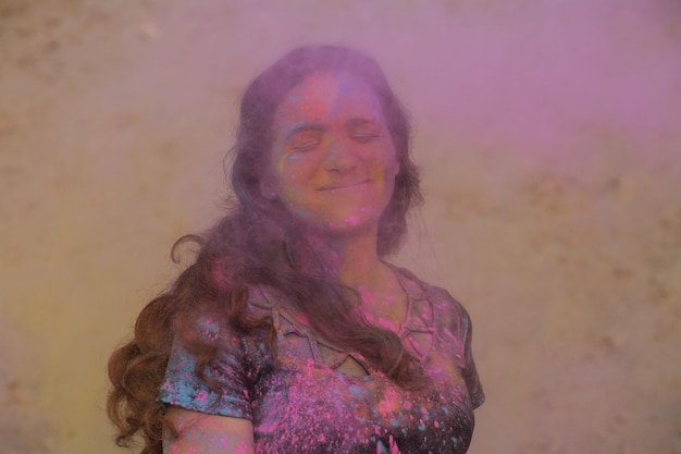Linda mulher morena, aproveitando o festival de Holi no deserto. Mulher posando com tinta rosa explosiva