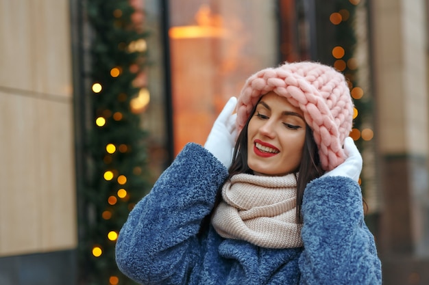 Linda mulher morena com casaco andando na cidade no inverno. Espaço vazio