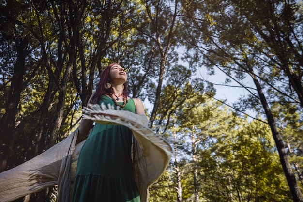 linda mulher morena dançando na floresta matinal no verão