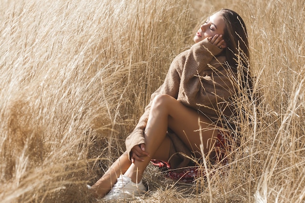 Linda mulher morena posando no campo de trigo