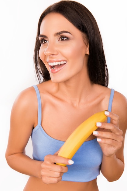 Linda mulher morena segurando uma banana