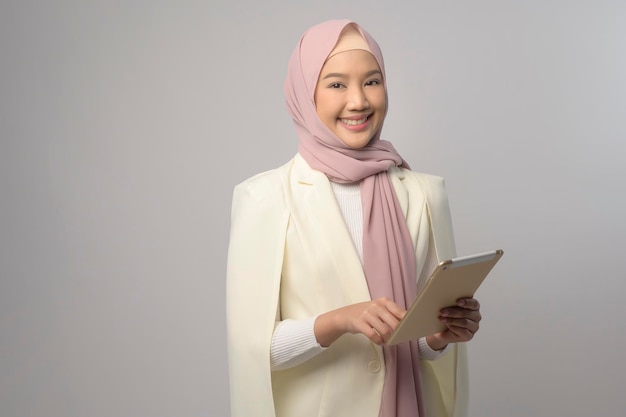 Linda mulher muçulmana com hijab usando tablet sobre o conceito de tecnologia de fundo branco x9