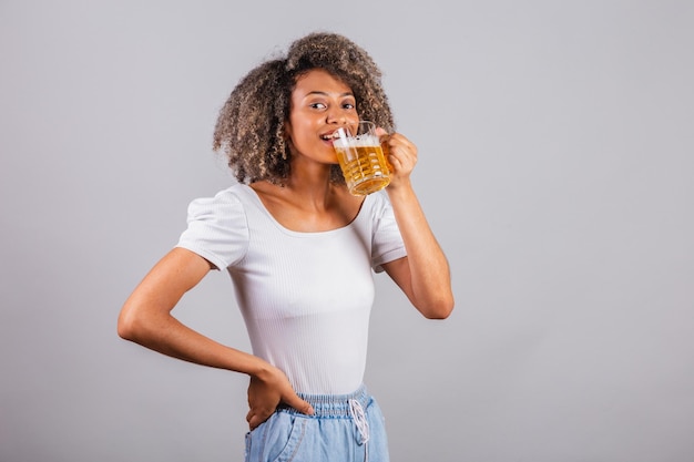 Linda mulher negra brasileira em roupas casuais, segurando um copo de cerveja