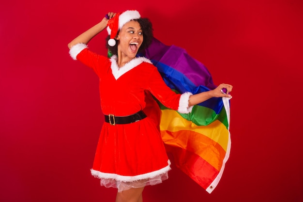 Linda mulher negra brasileira vestida de papai noel mamãe claus com bandeira lgbt diversidade gays e lésbicas