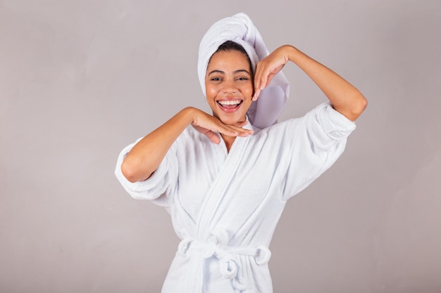 Linda mulher negra brasileira vestindo roupão e toalha closeup estética de spa de fotos mostrando bem-estar de delicadeza de beleza