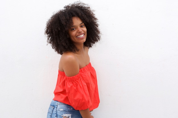 Linda mulher negra com cabelo encaracolado sorrindo contra fundo branco