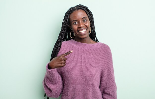 Linda mulher negra parecendo orgulhosa, confiante e feliz, sorrindo e apontando para si mesma ou fazendo o sinal número um