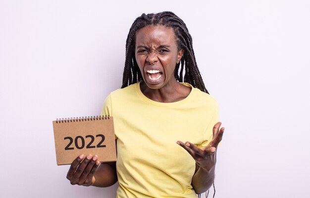 Linda mulher negra parecendo zangada, irritada e frustrada. Conceito de calendário 2022