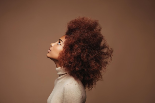 Foto linda mulher negra retrato da beleza de uma mulher afro-americana com pele limpa e saudável em fundo bege sorrindo linda garota afro cabelos pretos cacheados