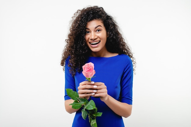 Foto linda mulher negra sorridente com rosa usando vestido azul