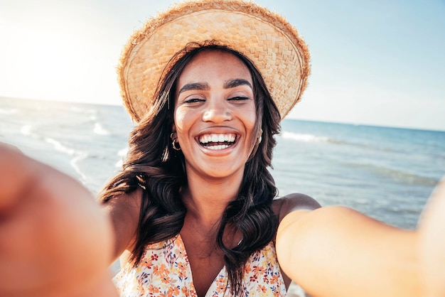 Linda mulher negra tomando selfie na praia