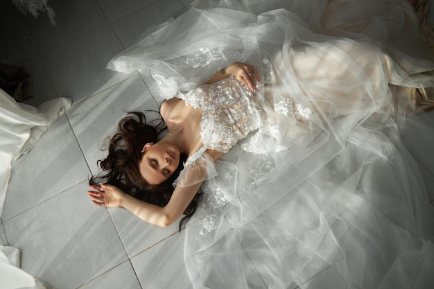 Linda mulher noiva em vestido de casamento branco olhar romântico mulher descansando fabulosa princesa elegante senhora com cabelo comprido fundo interior estilo loft