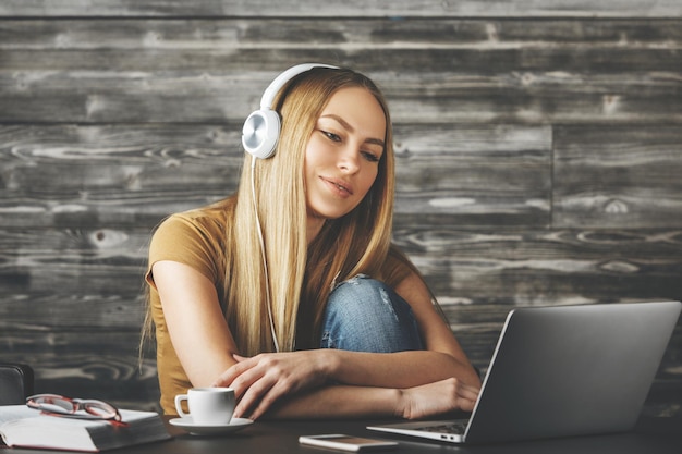 Linda mulher ouvindo música no local de trabalho