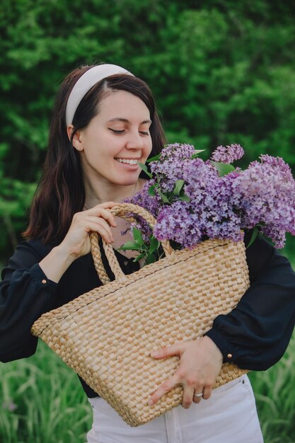 Linda mulher posando com flores lilás o verão está chegando