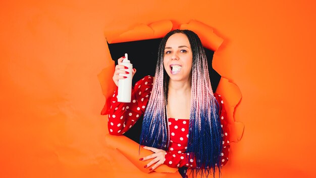 Foto linda mulher pressionando chantilly na boca uma garota elegante em um vestido vermelho brilhante comendo chantilly da garrafa