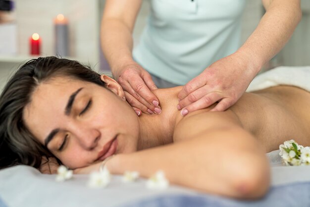 Linda mulher recebe massagem restauradora nas costas no salão spa Conceito de tratamento de beleza