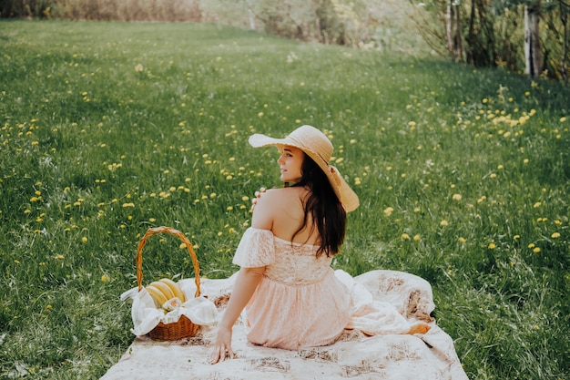 Linda mulher relaxada em um chapéu de palha em um piquenique