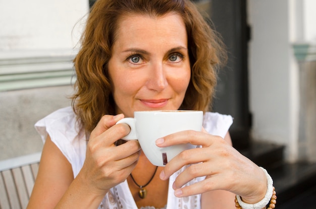 Linda mulher relaxar com uma xícara de café na mão