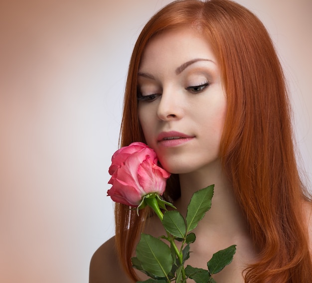 Linda mulher ruiva com uma rosa