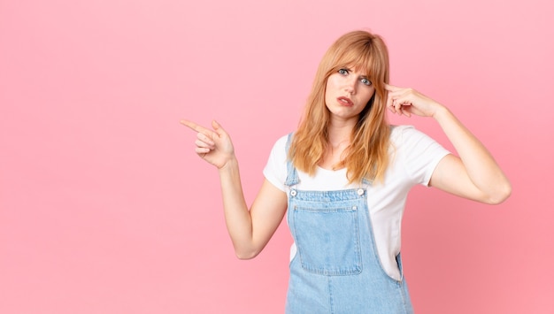 Linda mulher ruiva se sentindo confusa e intrigada, mostrando que você é louco