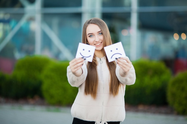 Linda mulher segurando cartas com um sorriso triste e engraçado.