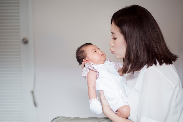 Linda mulher segurando um bebê recém-nascido em seus braços