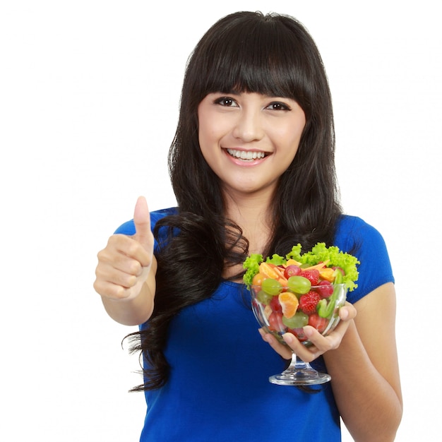 Linda mulher segurando um copo enorme de frutas