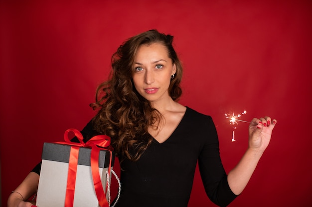 Linda mulher segurando uma caixa de presente de Natal e um diamante aceso