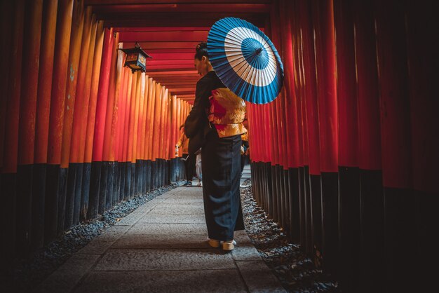 Linda mulher sênior japonesa andando no santuário de fushimi inari em Kyoto