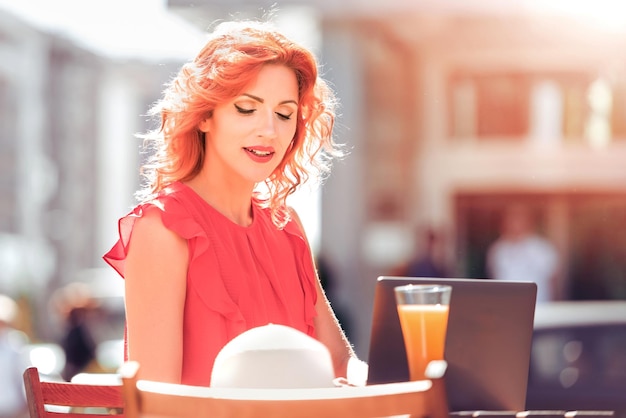 Linda mulher sentada em um café com laptop