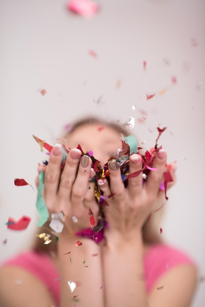 Foto linda mulher soprando confete na festa aérea celebração de véspera de ano novo isolada em fundo branco