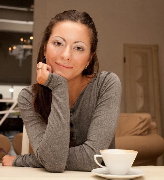 Foto linda mulher sorridente tomando café. casa.
